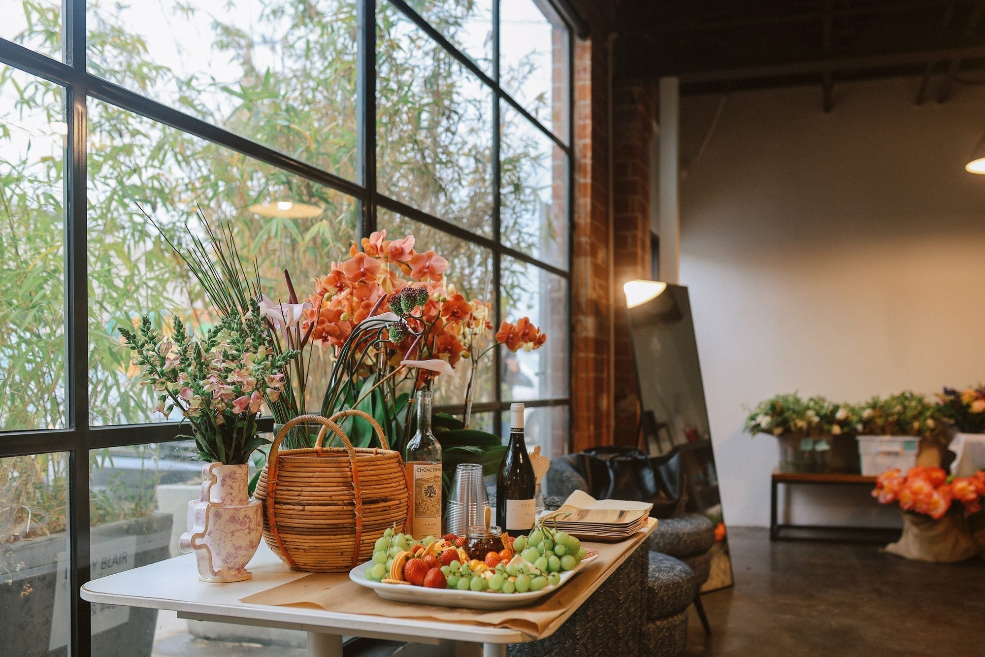 Corporate event flowers on a bar and buffet table with orchids and seasonal blooms in a Los Angeles event venue