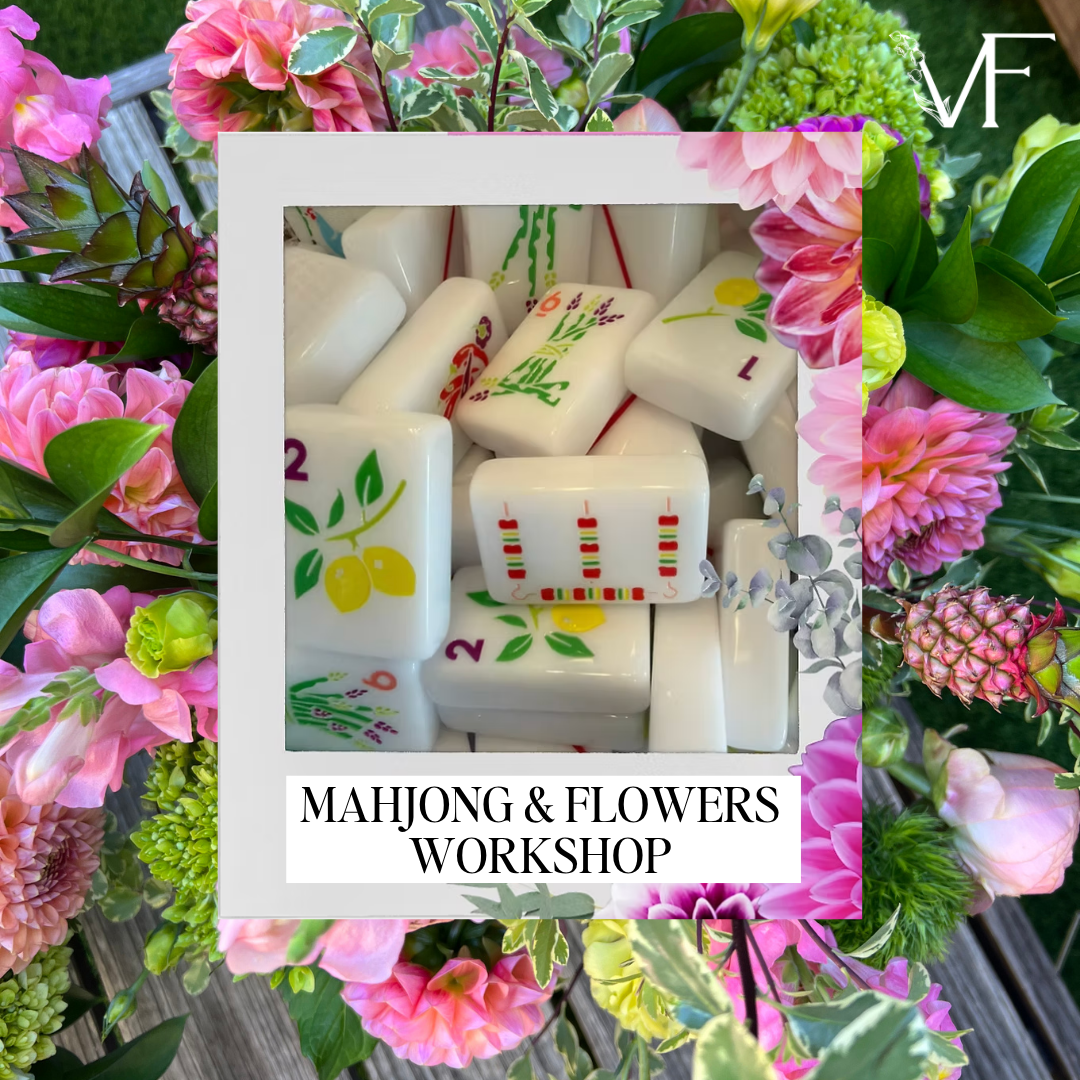 A promotional graphic for a 'Mahjong & Flowers Workshop' featuring a central white-bordered photo of white mahjong tiles with colorful floral engravings, surrounded by a border of pink and green flowers. A white 'VF' monogram logo is visible in the top right corner.